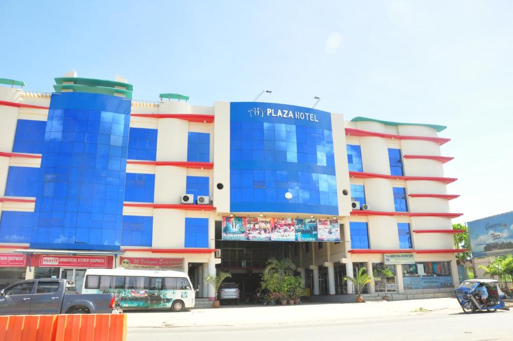 公主港A＆A广场酒店的一座蓝色和白色的建筑,前面有汽车停放