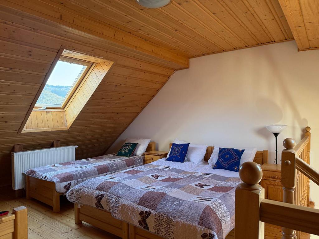 een slaapkamer met 2 bedden op een zolder bij Dom Madeyski in Szczawnica