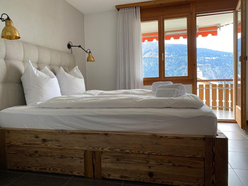 ein großes Bett in einem Zimmer mit Fenster in der Unterkunft Apartment Val Biala in Laax