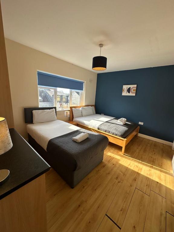 a hotel room with two beds and a window at Waterlane Apartments in Galway