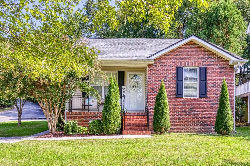 a red brick house with a door and trees at Sparkling Waters in Pigeon Forge