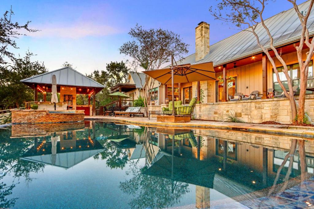 una casa con piscina di fronte a una casa di Casa Colinas a Wimberley
