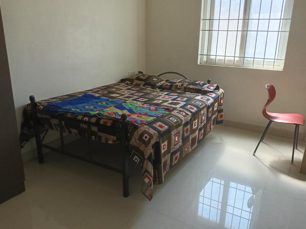 a bed in a room with a table and a chair at Golden Rooms banglore in Bengaluru