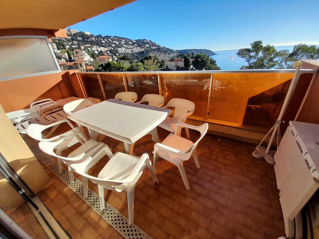 une table et des chaises sur un balcon avec vue dans l'établissement appartement côte d'azur vue mer, à Roquebrune-Cap-Martin