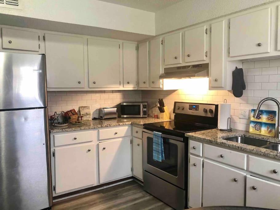 a kitchen with white cabinets and a stainless steel refrigerator at Townhomes Near the Bay - #1 in Grand Bay