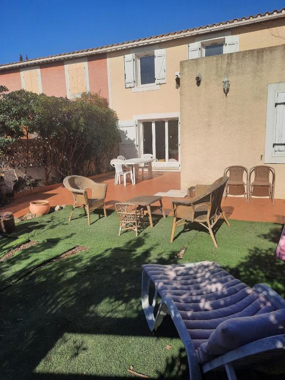 - une cour avec des chaises, une table et des chaises dans l'établissement Maison Gruissan village 90m2 avec jardin a 1km de la plage, à Gruissan