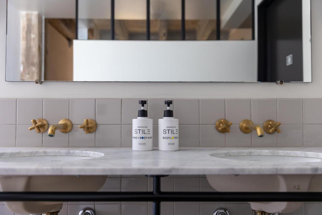 a bathroom with two sinks with two shampoo bottles on it at STILE Downtown Los Angeles by Kasa in Los Angeles
