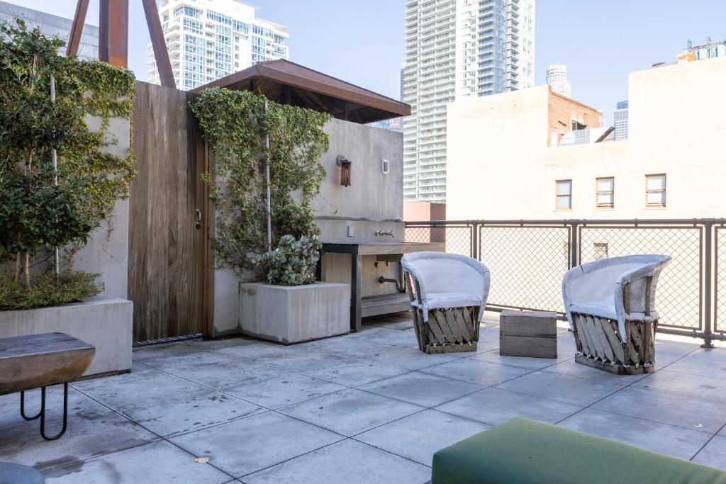 a patio with chairs and a table on a balcony at STILE Downtown Los Angeles by Kasa in Los Angeles