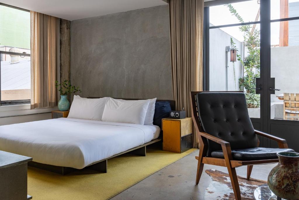 a bedroom with a bed and a chair at STILE Downtown Los Angeles by Kasa in Los Angeles