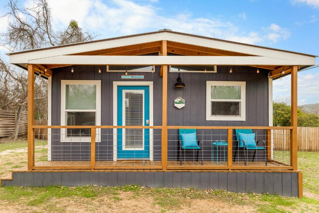 a tiny house with a porch and blue chairs at Hunka Hunka Cabin in New Braunfels