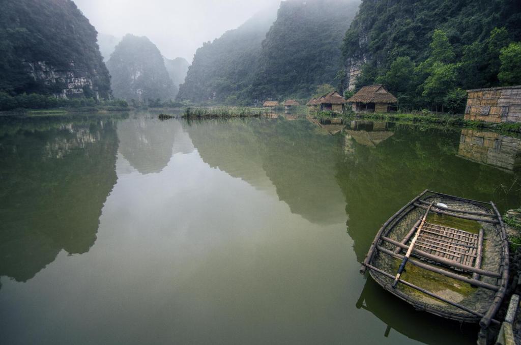 un barco sentado en el agua en un río en Hello Valley Bungalow, en Vũ Lâm