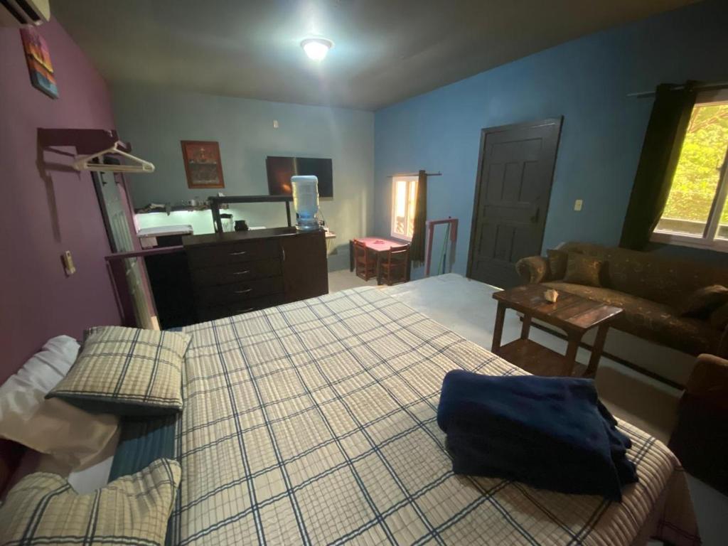 a living room with a bed and a couch at Airport Inn Roatan in Coxen Hole