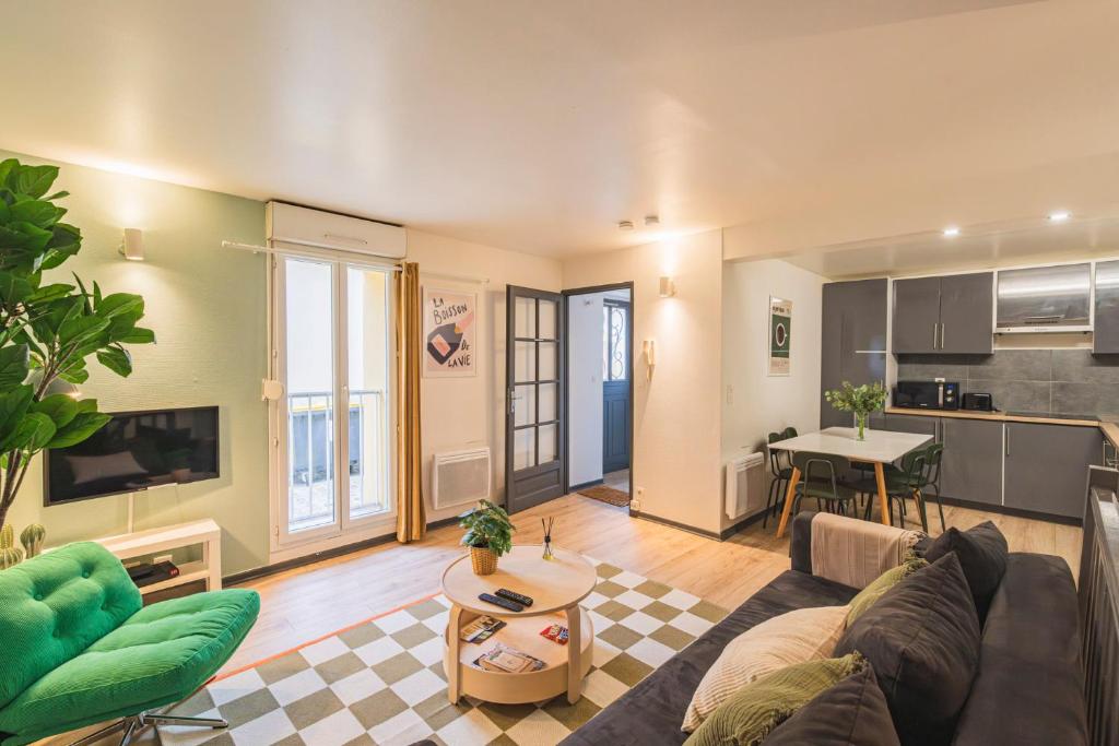 un salon avec un canapé et une table dans l'établissement Le Pastel - 10 couchages - proche Cathédrale, à Reims