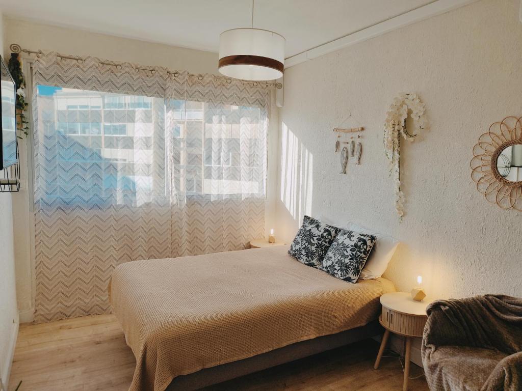 une chambre avec un lit avec deux oreillers dessus dans l'établissement Le Nacre, à Balaruc-les-Bains