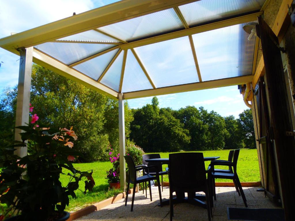 un pavillon avec des chaises et une table dans un jardin dans l'établissement a 10 mn d Angers maisonnette independante, à Brain-sur-lʼAuthion