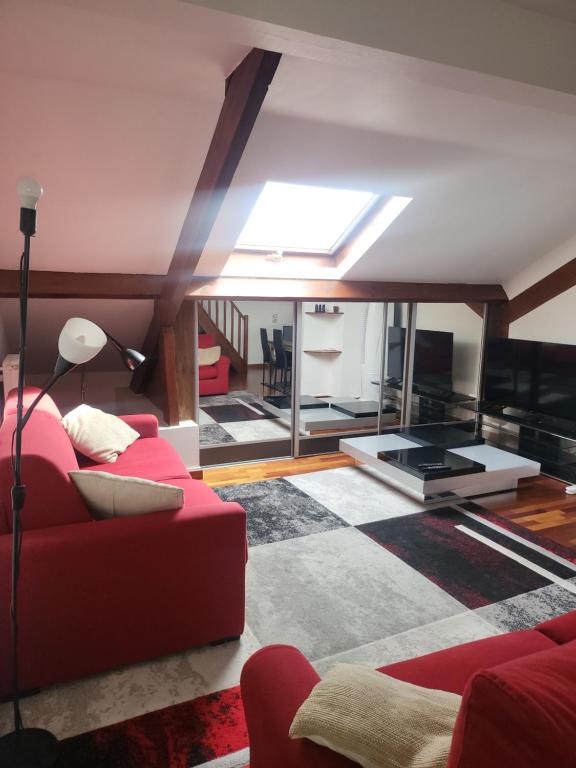 un soggiorno con un divano rosso e una TV di GRAND DUPLEX proche de PARIS a Saint-Maur-des-Fossés