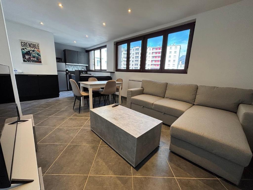 un salon avec un canapé et une table dans l'établissement Au Pied des Alpes, à Grenoble