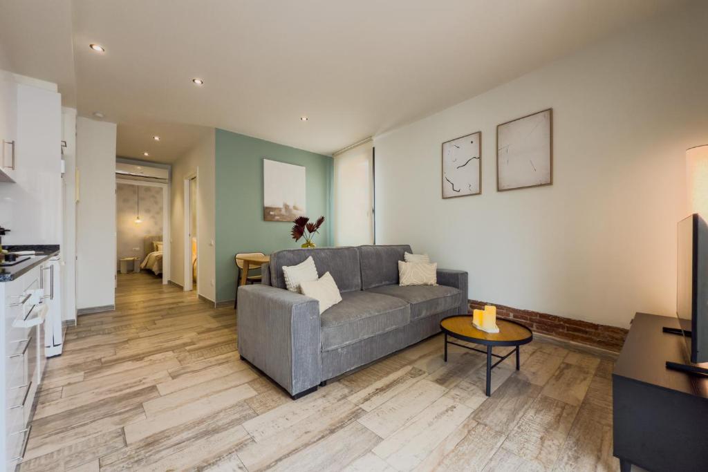 una sala de estar con un sofá y una mesa en Novus Homes Barcelona Plaza España, en Barcelona