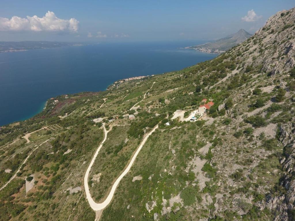 a road on the side of a mountain near the ocean at Mountain Stone Villa with pool in Stanići