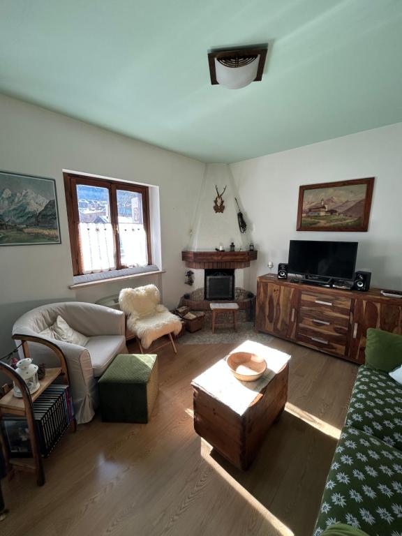a living room with a couch and a fireplace at Casa Lucrezia - Valbruna in Valbruna