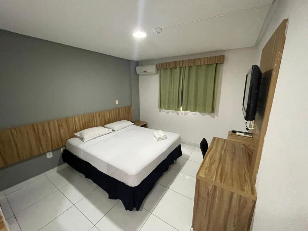 um quarto com uma cama e uma televisão em CR Hotel Bueno em Goiânia