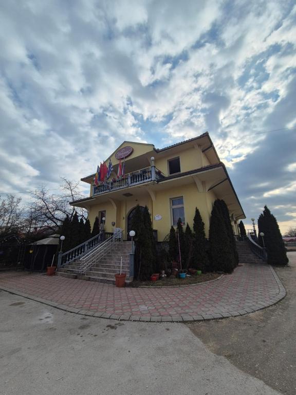 a large yellow house with a balcony on top at Vila Vienna in Zaječar
