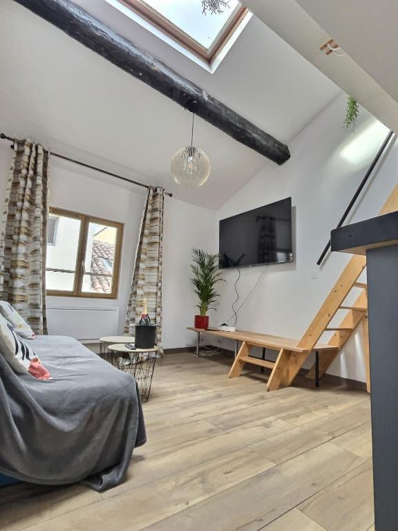 Cette chambre comprend un lit, un bureau et une télévision. dans l'établissement Charmant duplex Béziers centre, à Béziers