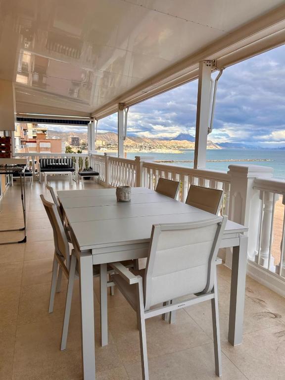 a white table and chairs on a balcony with the ocean at Beach House Brotonss in El Campello
