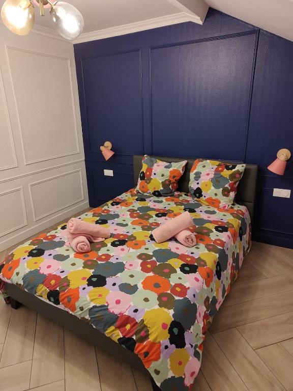 une chambre avec un lit avec une couette colorée dans l'établissement Parisian style 10 min from Paris, à Aubervilliers