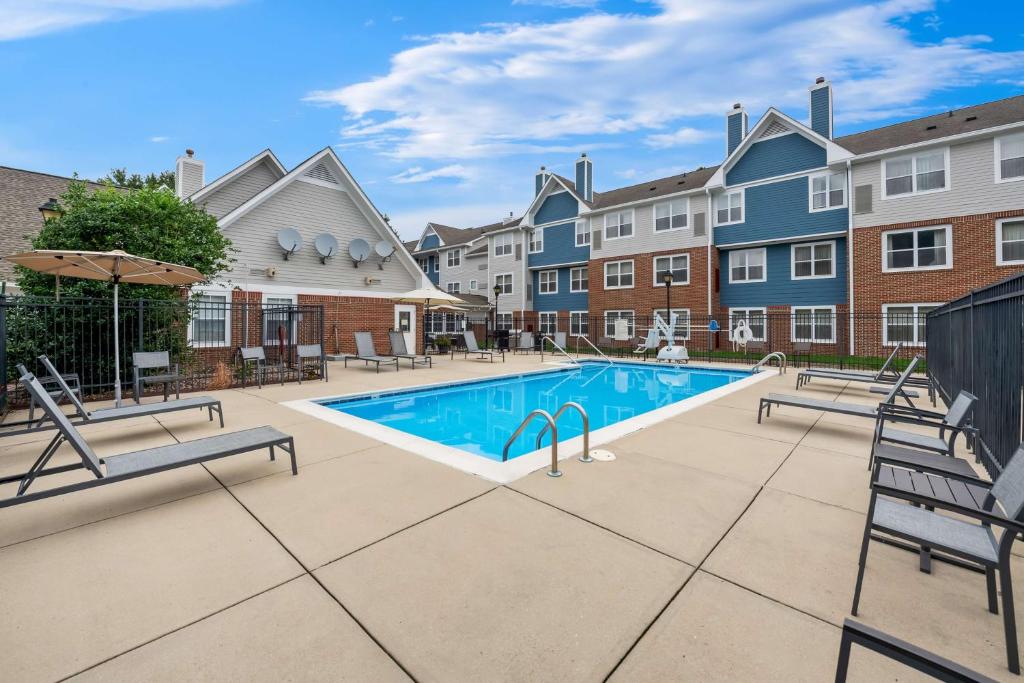 ケーリーにあるSonesta ES Suites Raleigh Caryの中庭のスイミングプール(パティオ家具付)とアパートメントを提供しています。
