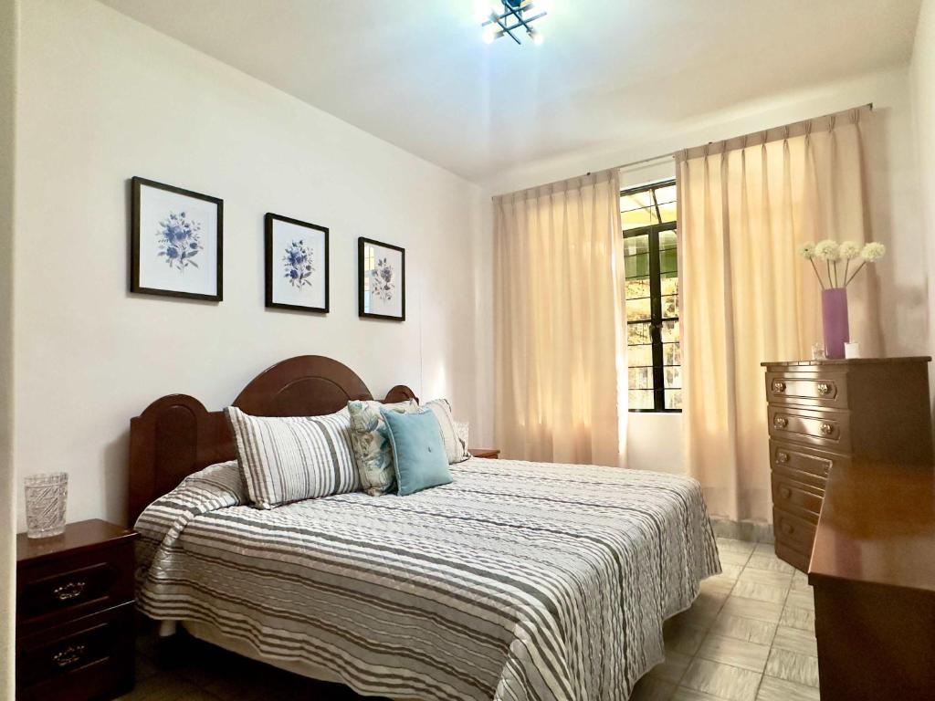 a bedroom with a bed and a dresser and a window at Villa by Centro Medico Occidente 3 br in Guadalajara