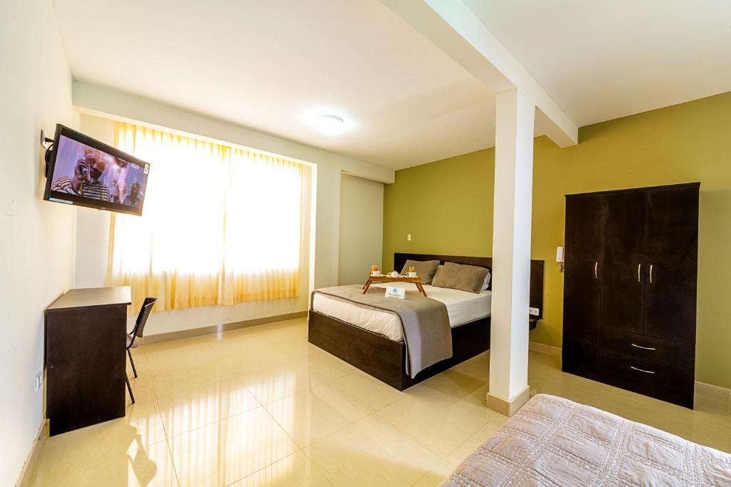 a bedroom with a bed and a large window at Villa Santa in Chiclayo