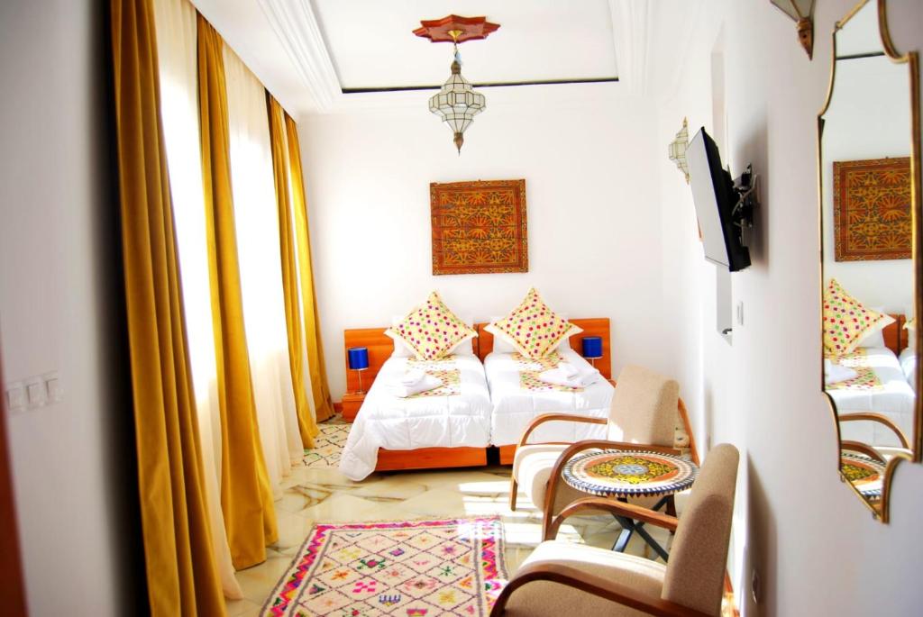 1 Schlafzimmer mit 2 Betten und Stühlen in einem Zimmer in der Unterkunft Dar terrae plus in Chefchaouen