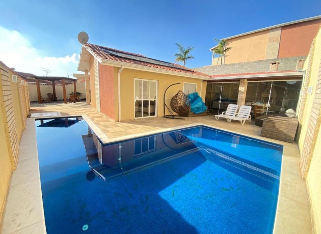 a swimming pool in front of a house at Casa de campo em Mairinque in Mairinque