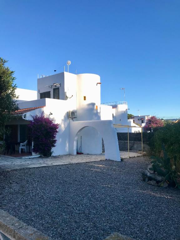 a white building with an arch in front of it at Casa Límon in Torredembarra