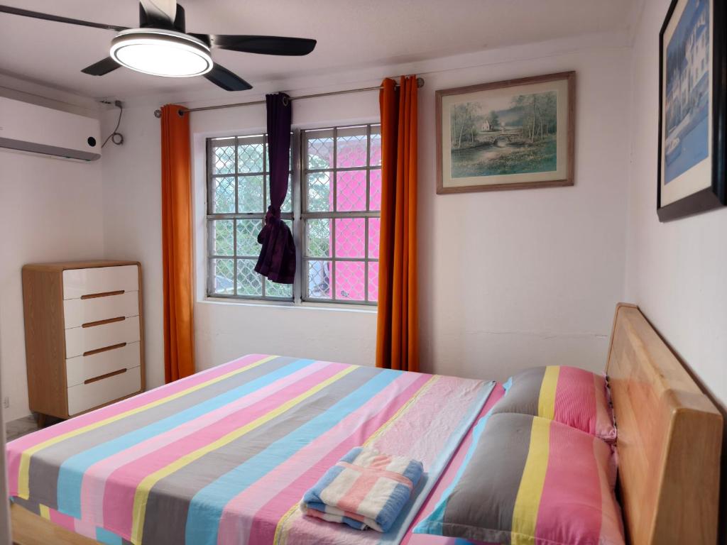 a bedroom with a bed with a colorful blanket at Da Pink And White Palace in Nassau