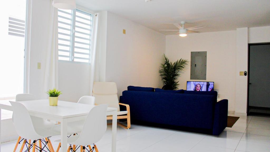 a living room with a blue couch and a table at Arecibo Hotel 2104 in Arecibo