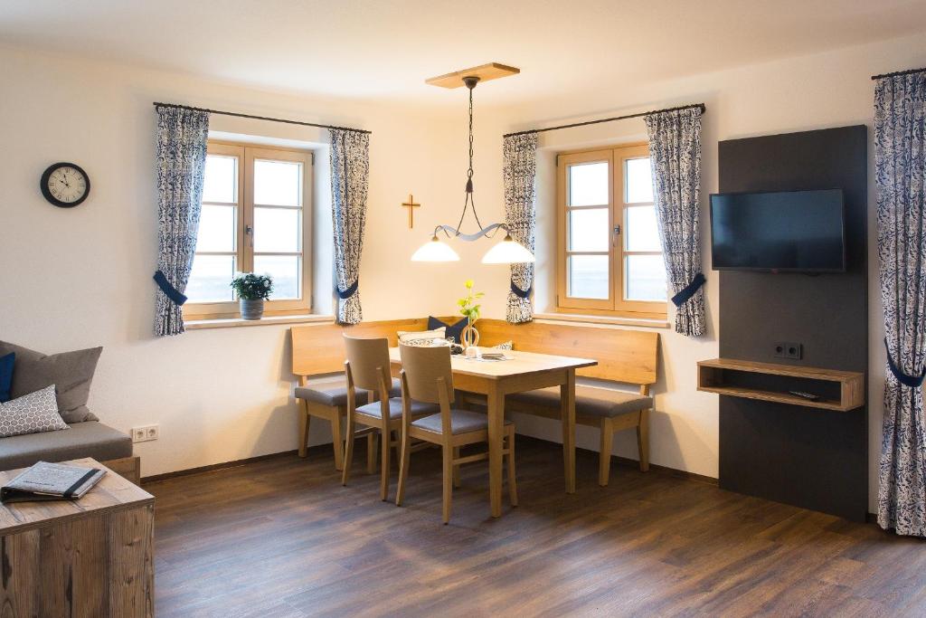 a dining room and living room with a table and chairs at Schleipfnerhof Urlaub auf dem Bauernhof in Bernau am Chiemsee