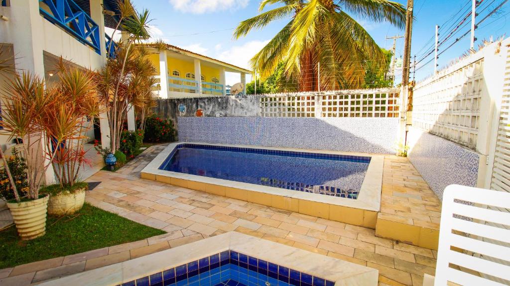 a swimming pool in a yard next to a house at Casa da Nina | Beira-mar in Tamandaré