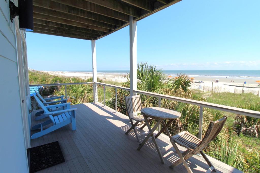 a porch with a table and chairs and the beach at The One in Folly Beach