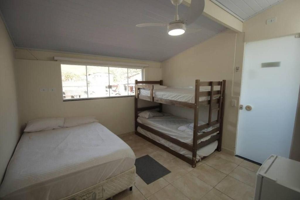 ウバトゥバにあるSuites Familia Otavianoの二段ベッド2台と窓のある寝室