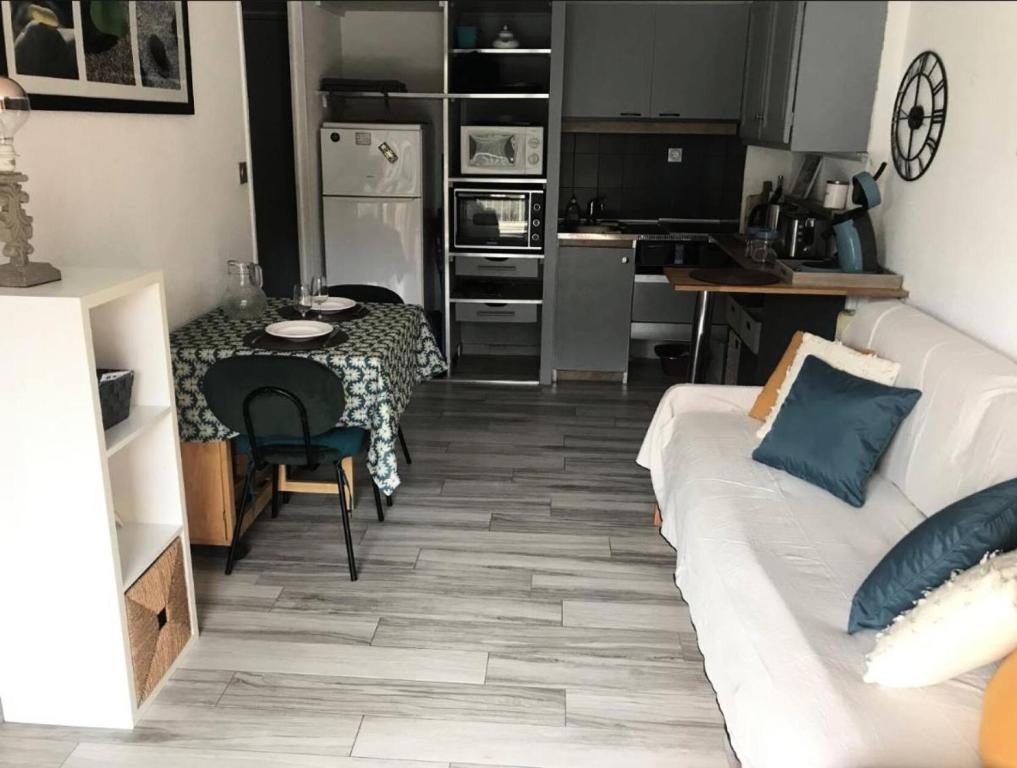 un salon avec un canapé blanc et une table dans l'établissement Résidence Verdon - Coquet appartement 2 couchages à Six Fours les Plages MAE-7531, à Six-Fours-les-Plages