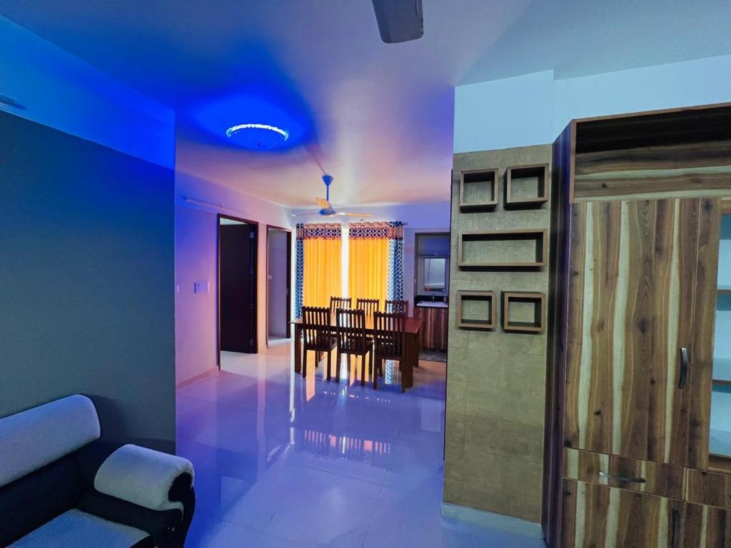 Una sala de estar con un sofá y un comedor. en Luxe Oasis Palmgrove Oppo Lulu Mall, en Trivandrum