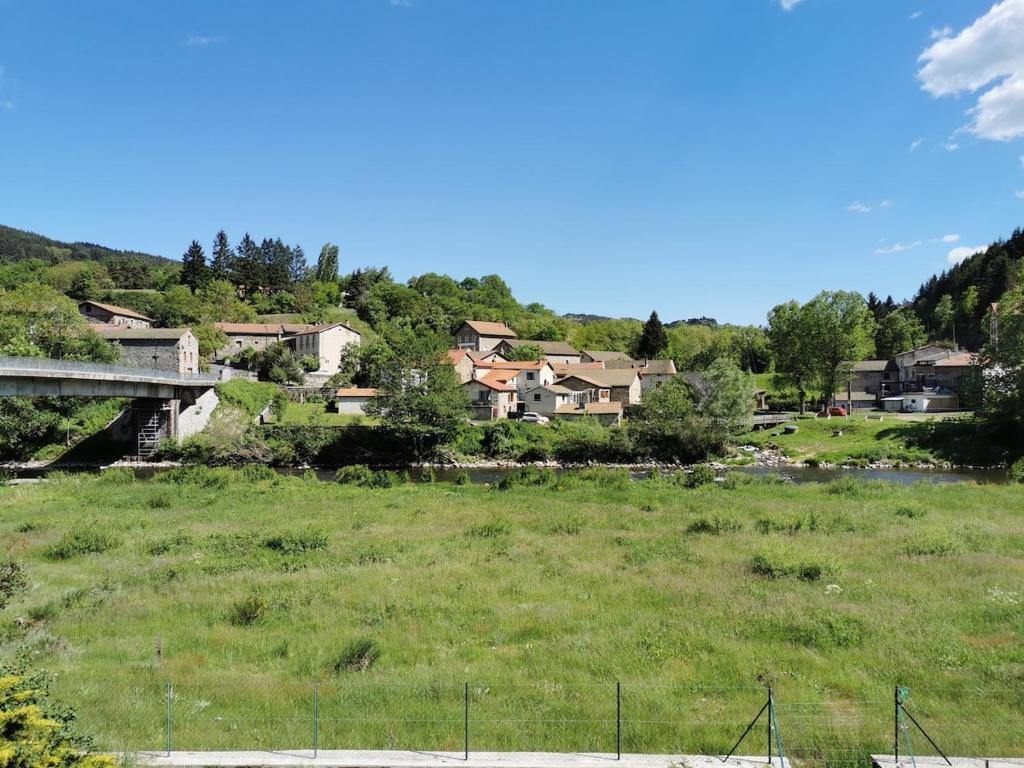 un groupe de maisons sur une colline avec un pont dans l'établissement Ker Soazig, à Alleyras