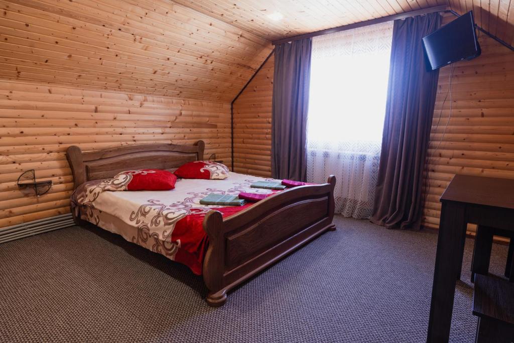 a bedroom with a bed with red pillows and a window at Відпочинковий комплекс "Alpha Plus" in Yablunytsya