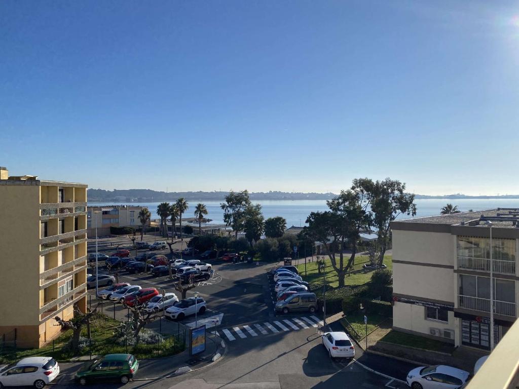 vue aride d'un parking avec des voitures garées dans l'établissement T1 avec terrasse, parking & climatisation à Balaruc-les-Bains - FR-1-553-283, à Balaruc-les-Bains