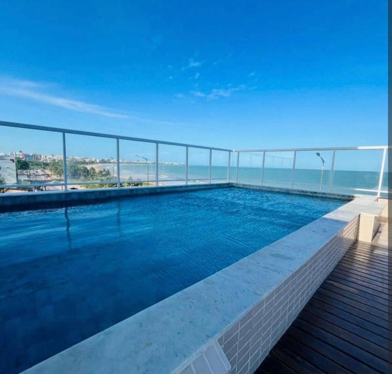 a swimming pool with a view of the ocean at Apartamento Beira Mar de João Pessoa PB in João Pessoa