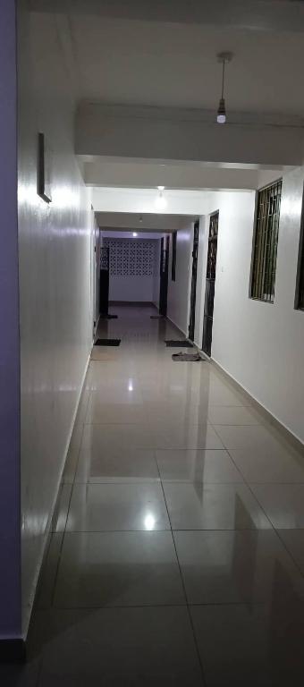 a hallway of a building with white walls and ailed floor at bamburi studio in Mombasa
