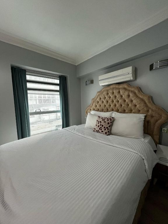 a bedroom with a large white bed with a window at Invivo Hotel in İzmir