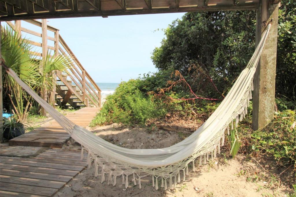 eine Hängematte am Strand neben dem Meer in der Unterkunft Oceanfront Nest Down in Folly Beach